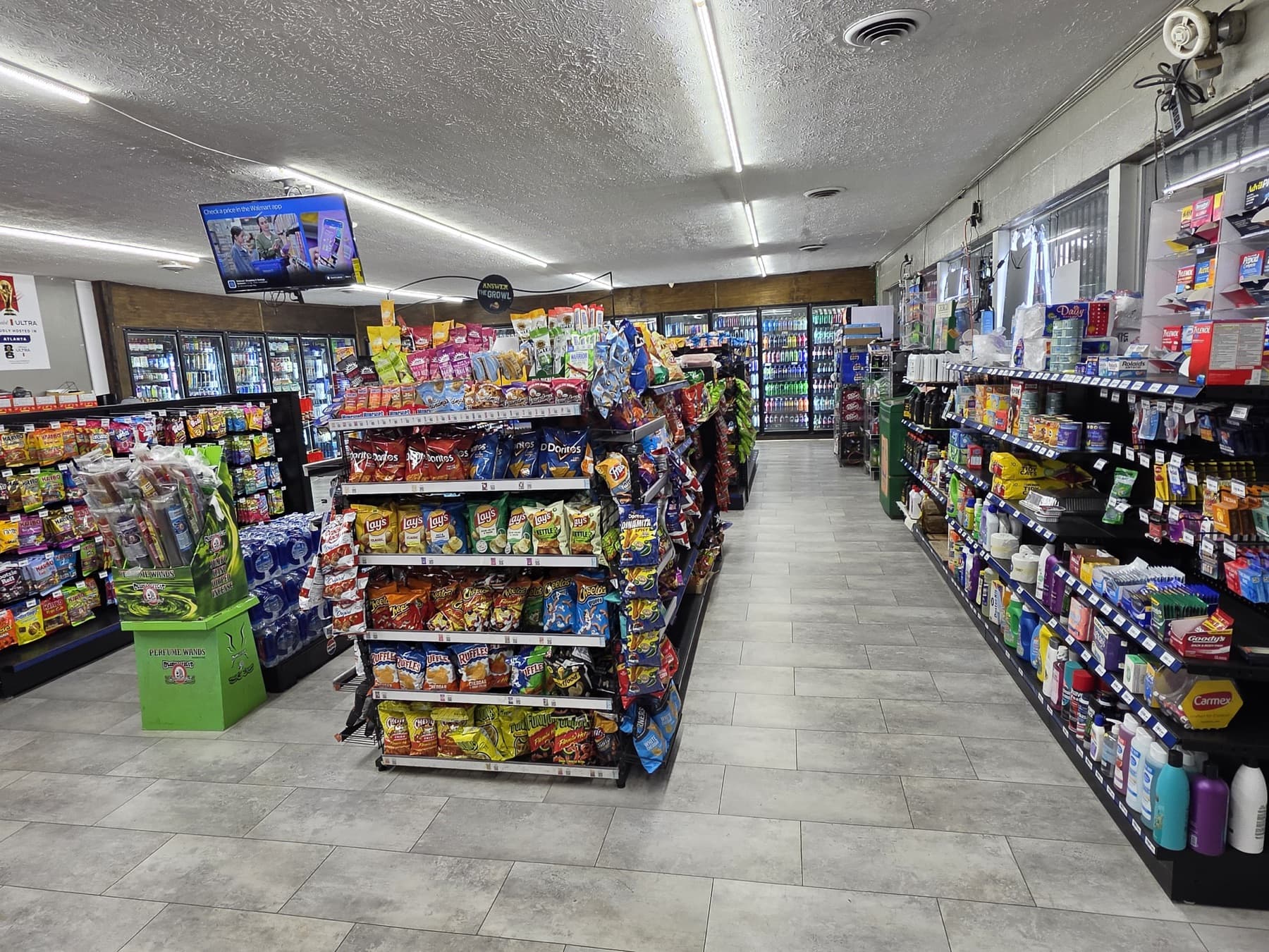A well-stocked aisle of chips, snacks and household items