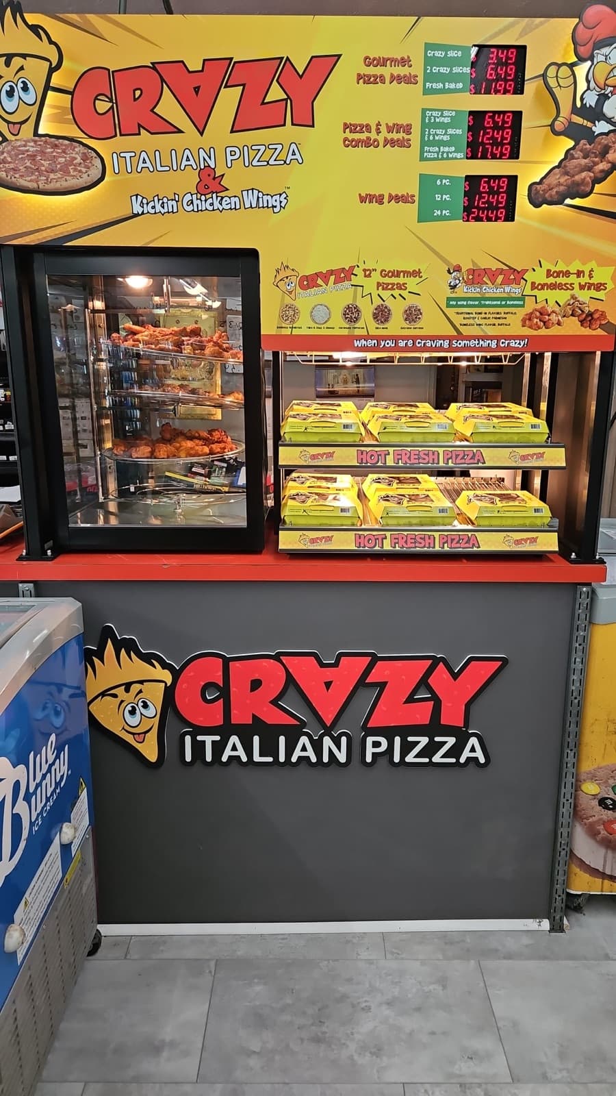 Crazy Italian Pizza counter inside Speedy Spot with hot fresh pizza and chicken wings